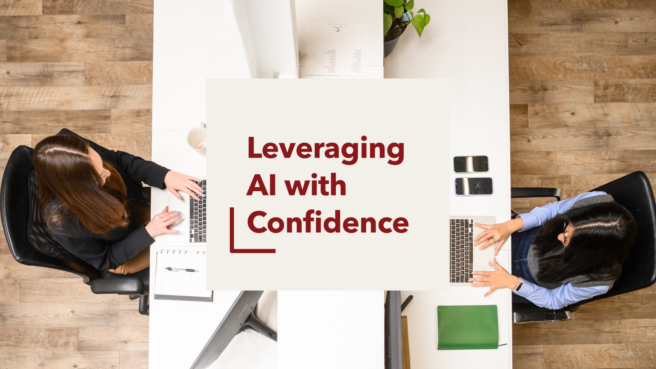 An aerial shot of two people working on their laptops. There is text overlaid that reads " Leveraging AI with Confidence"