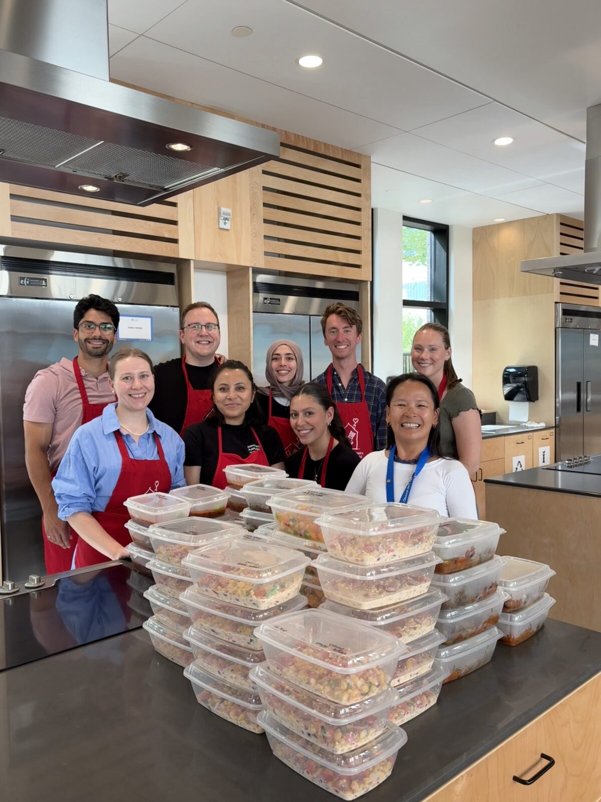 Group of Davis Pier team members at Ronald McDonald House with a bunch of meals prepared in front of them